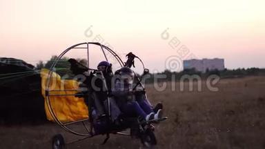 摩托车滑翔伞在机场和一个女孩和一个男人一起起飞，加速降落到空中